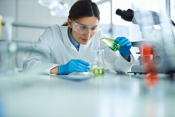 Young female  scientist working  with chemical substances in laboratory.