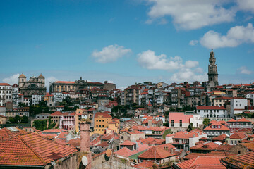 Obraz premium Skyline of a number of houses and the famous Clerigos Tower under a rich blue sky in Porto, Portugal. Epic skyline of a beautiful city with blue skies...