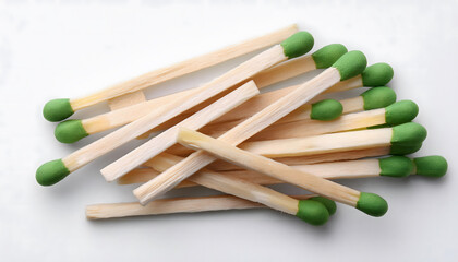 Wooden matches with green heads on white background flat lay