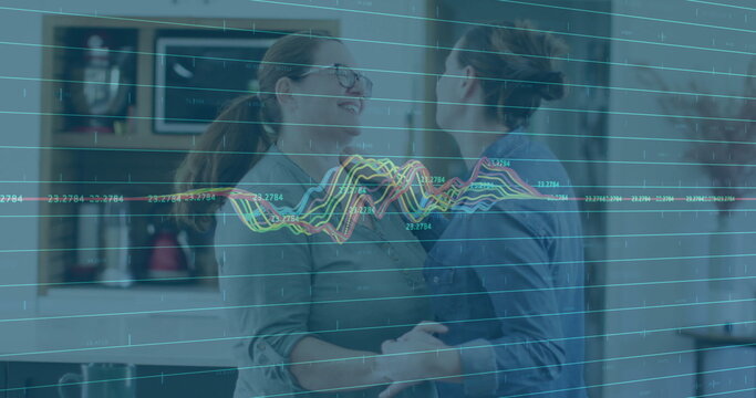 Smiling couple dancing in kitchen with data processing image over them