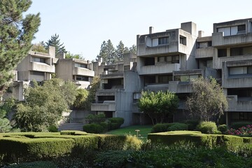 Fototapeta premium A brutalist residential complex with a series of geometric concrete blocks stacked in a rugged, imposing formation.Raw concrete.Brutalist architecture.Brutalism art.Brutalist design.