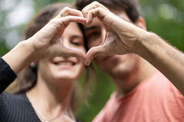 Fototapeta premium Young couple in love forming a heart with their hands