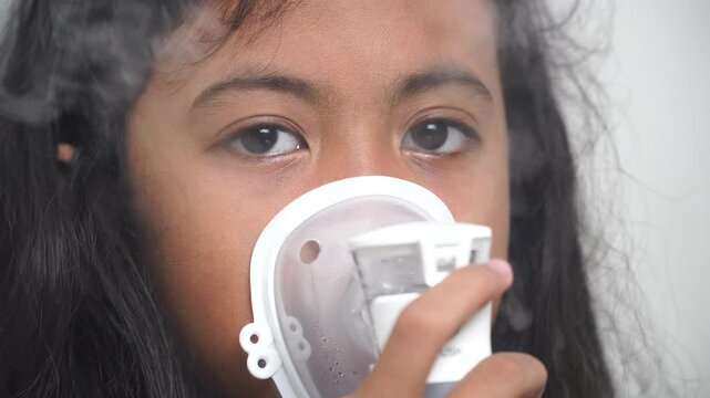 Little girl makes inhalation with a nebulizer. Children's asthma inhaler cough steam inhalation