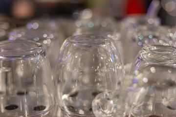 Glittering glassware reflects colorful holiday lights, creating a festive and magical atmosphere. The sparkling glasses hint at the celebrations to come.