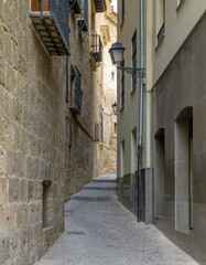 Fototapeta premium Small narrow alley between stone buildings in the city of Granada, Spain