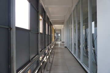 A small hallway in a building between rooms with balconies and holes for lighting.