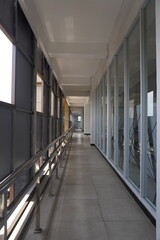 A small hallway in a building between rooms with balconies and holes for lighting.