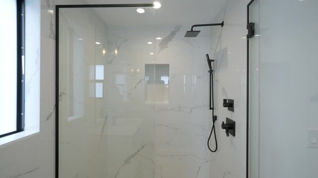 Modern, minimalist bathroom with large walk-in shower. Shower area features glass door and black frame with rainfall showerhead and handheld shower head mounted on wall