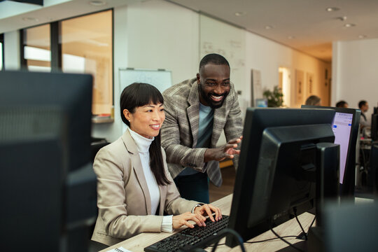 Diverse business people working together on office computer