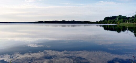 A peaceful lake reflecting mountains and the sky surrounded by trees and nature in Lakeville, MA