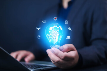 Idea innovate and concept. Hand holding a light bulb that shine glitter with icons, creative thinking concept success, management and digital transformation, data search, thinking, bulb, technology