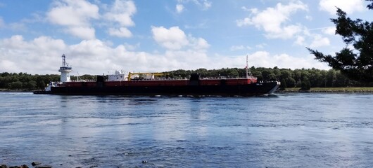 A large ship is traveling down Cape Cod Canal