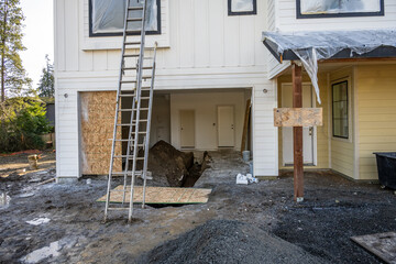 New house construction in progress, view into open garage with dirt floor and open plumbing pipe...