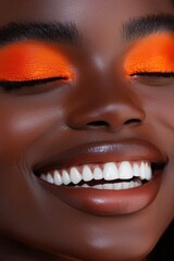 Fototapeta premium Radiant Portrait of a Smiling Woman with Vibrant Orange Eyeshadow and Flawless Skin, Emphasizing Joy and Confidence in a Close-Up Shot