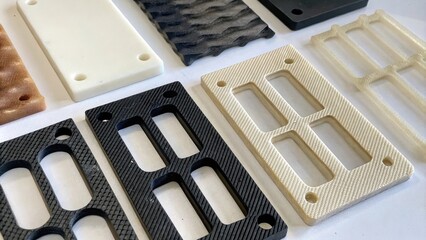 An assembly of varied lasersintered components laid out for inspection showcasing a range of textures and colors indicative of different materials used in the manufacturing