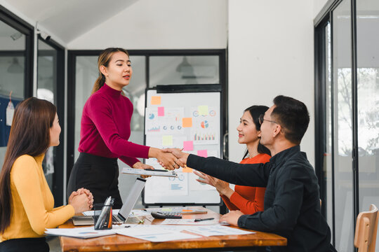 team collaborating in modern office with handshake