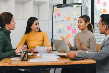 Team discussing project with charts and documents in office