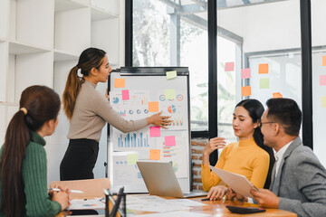 Team discussing data charts on whiteboard in meeting room