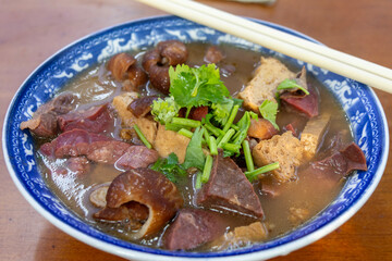 Bowl of Luzhu huoshao (pork stew with bread) on table