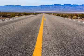 A long, empty road with a yellow line down the middle