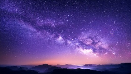 Naklejka premium Majestic night sky with the Milky Way galaxy over a mountain range.