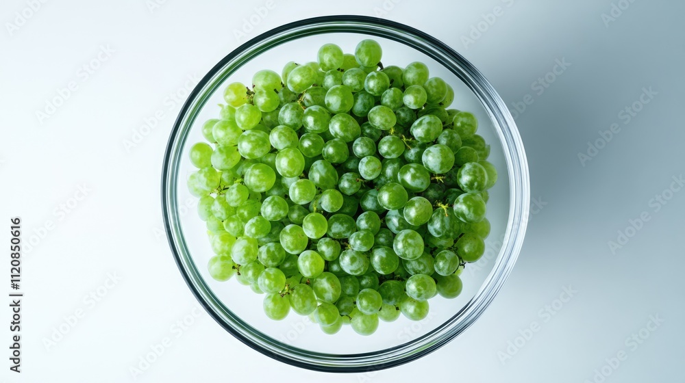 Poster aerial view of fresh green grapes piled in a clear glass bowl on a white background showcasing vibra