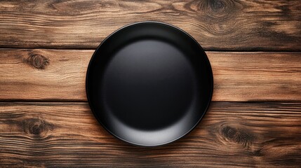 Intermittent fasting concept with empty black plate on rustic wooden table representing nutrition and fasting periods flat lay overhead view