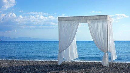 Fototapeta premium Beachfront wedding arch with flowing white drapes against a serene coastal backdrop of blue skies and calm waters. Perfect for romantic events.