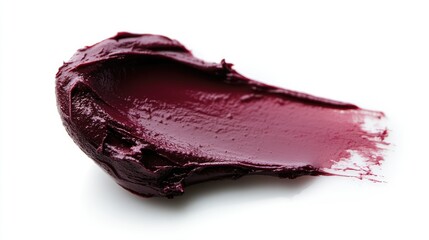Obraz premium Elegant burgundy lipstick swatch on a clean white background showcasing texture and color for beauty and cosmetics branding.