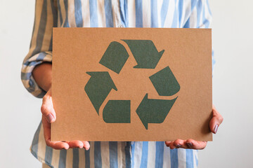 Female hands holding signboard recycling reusing zero waste circular arrow go green closeup