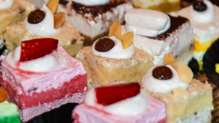 Appetizing array of mini cakes featuring creative combinations of flavors and toppings, sure to satisfy any sweet tooth