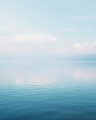 Obraz premium A serene view of calm waters reflecting a soft blue sky.