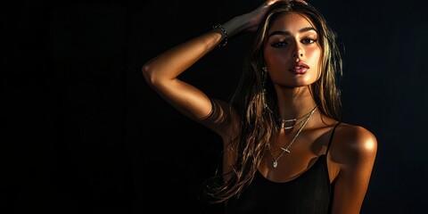 Studio shot of a model posing with dramatic lighting and a black backdrop