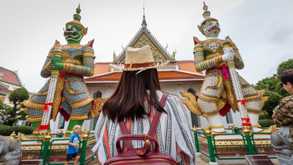 Obraz premium Asian girl tourist smiling while visiting Wat Arun or Temple of Dawn backpacker women