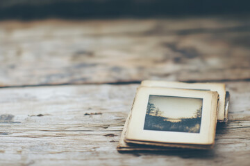 Vintage photographs laid on rustic wooden surface, capturing timeless memories with a nostalgic ambiance.
