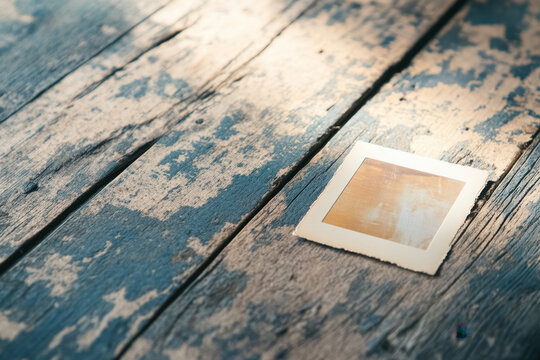 A faded vintage photo lies on a weathered wooden surface, capturing nostalgia and timeless memories in a rustic setting with soft, warm lighting.
