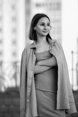 Portrait of a young beautiful dark-haired girl in an urban environment. Black and white photo.