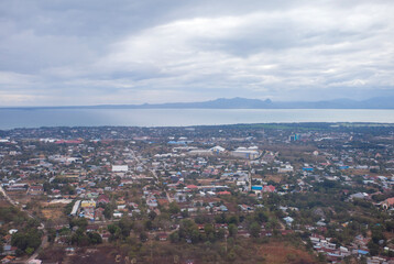 Obraz premium Aerial view of Kupang city, the capital of East Nusa Tenggara Province, Indonesia. Urban landscape with coastline, settlements, built-up areas and some agricultural areas.