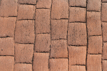 Weathered reddish-brown brick paved surface abstract textured background
