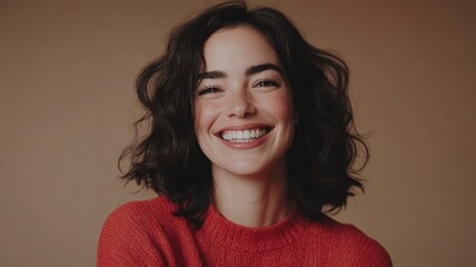 Fototapeta premium Studio portrait of a confident young woman with crossed arms, smiling expression, and hair tied up in a bun