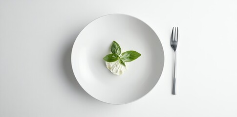 A small portion of food with basil on a white plate