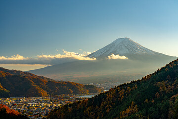 夕日に照らされた街並み越しの富士山