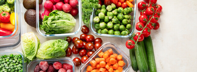 Boxes with fresh raw vegetables on table.