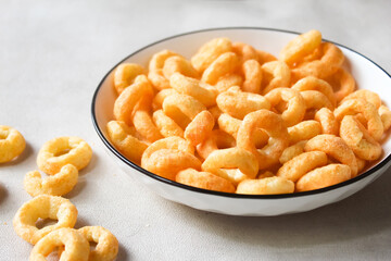 a plate of cheese flavored ring snacks