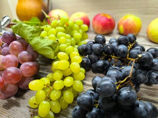grapes are green red blue on the table surrounded by fruits