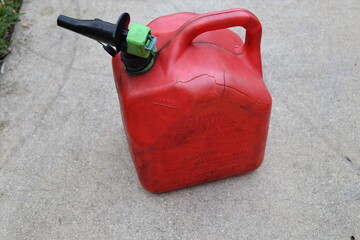 Used plastic gas can red color on asphalt