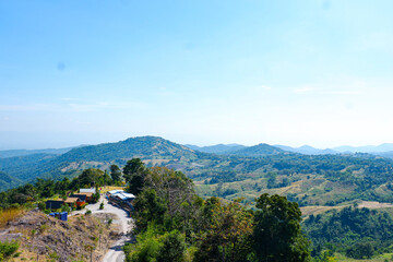 High angle with mountain peaks looking as far as the eye can see against the blue sky.