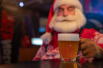 Santa Claus drinking beer at a bar. 
