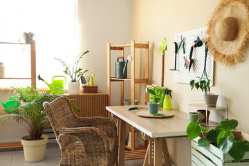 Interior of workshop with gardening tools, pegboard and workplace