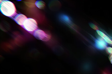 Abstract colorful bokeh with bright lens flare on dark background. Digital design, night party themes, futuristic looks, vibrant patterns. Blurry sparkling particles in the air, festive light effect
